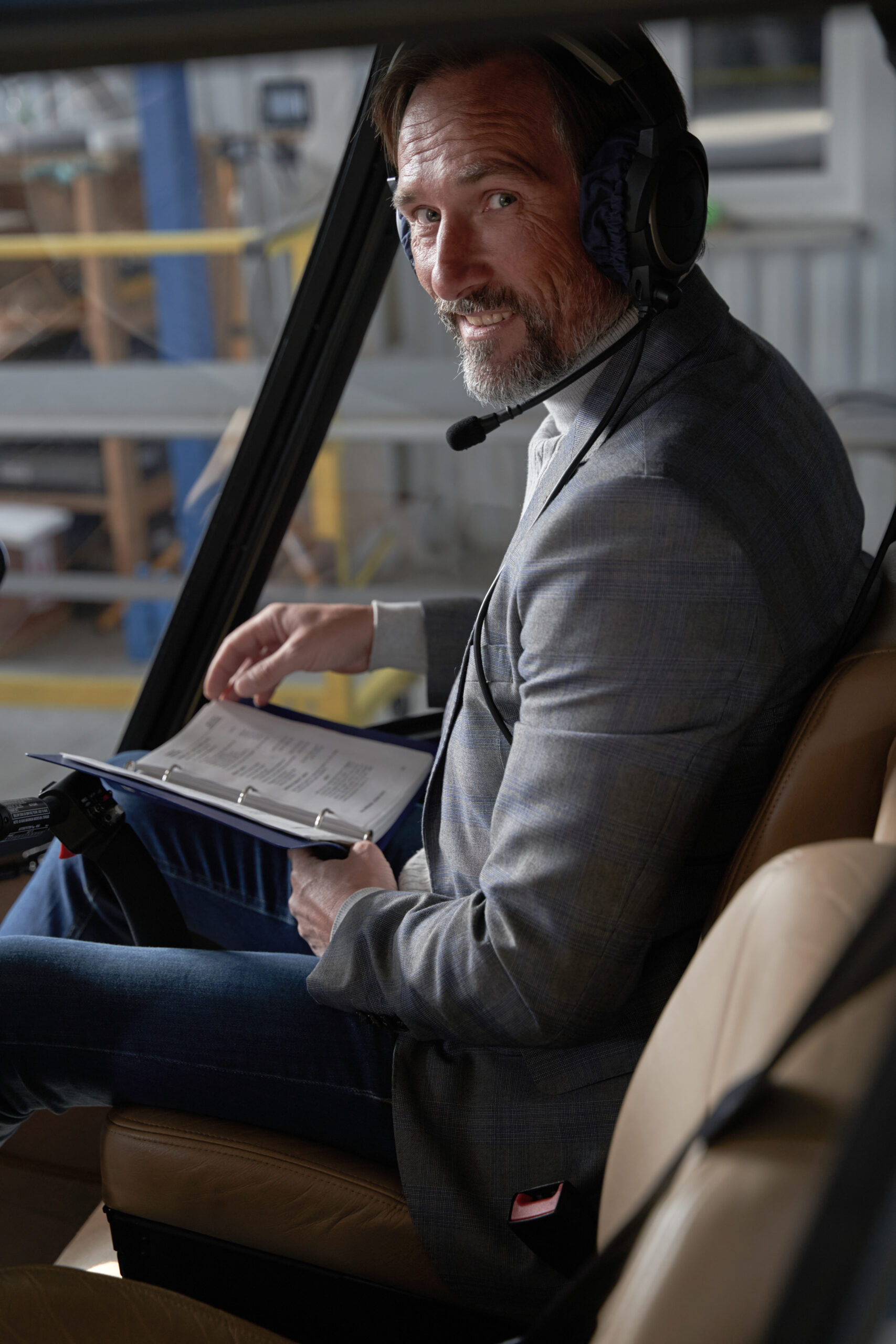 Cheerful aviator in headphones sitting in chopper About Metrotalk